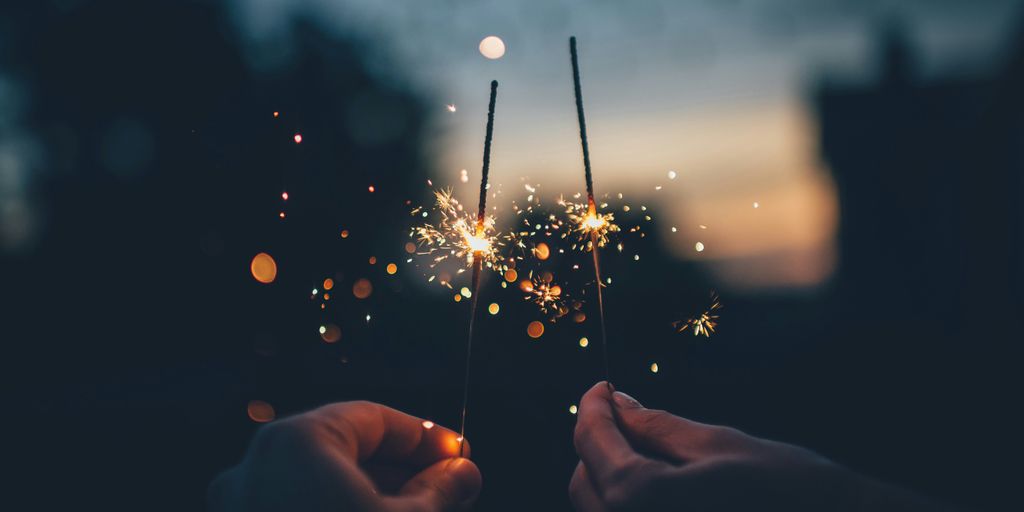 person holding fire cracker shallow focus photography