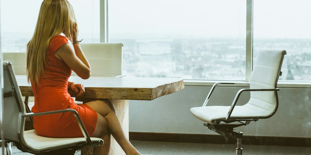 woman talking through mobile phone while sitting on swivel armchair