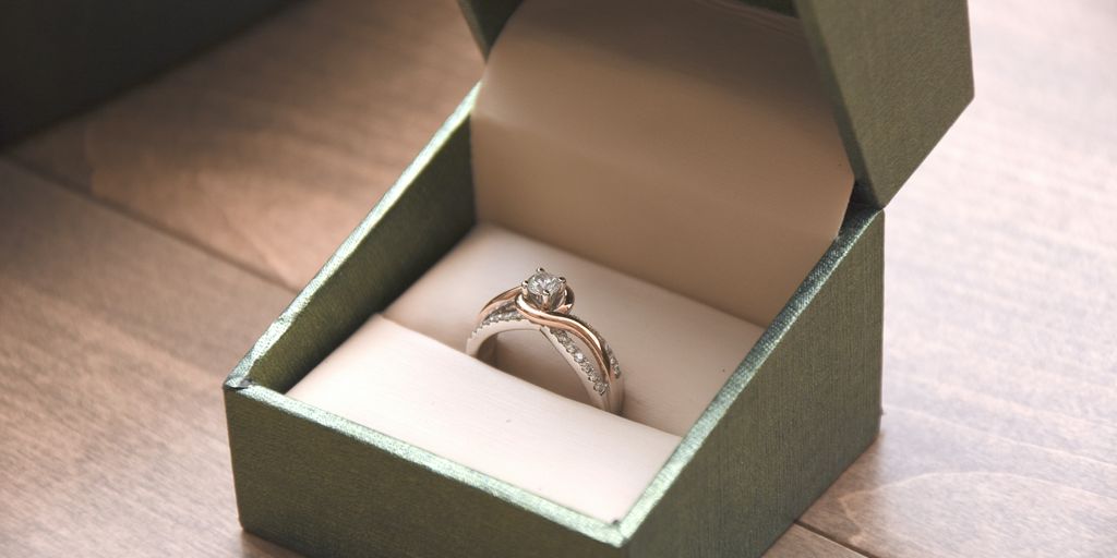 silver-colored ring with gemstone in a box