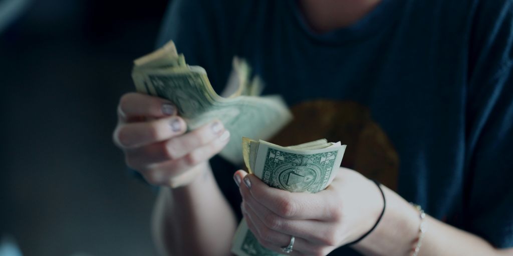 focus photography of person counting dollar banknotes